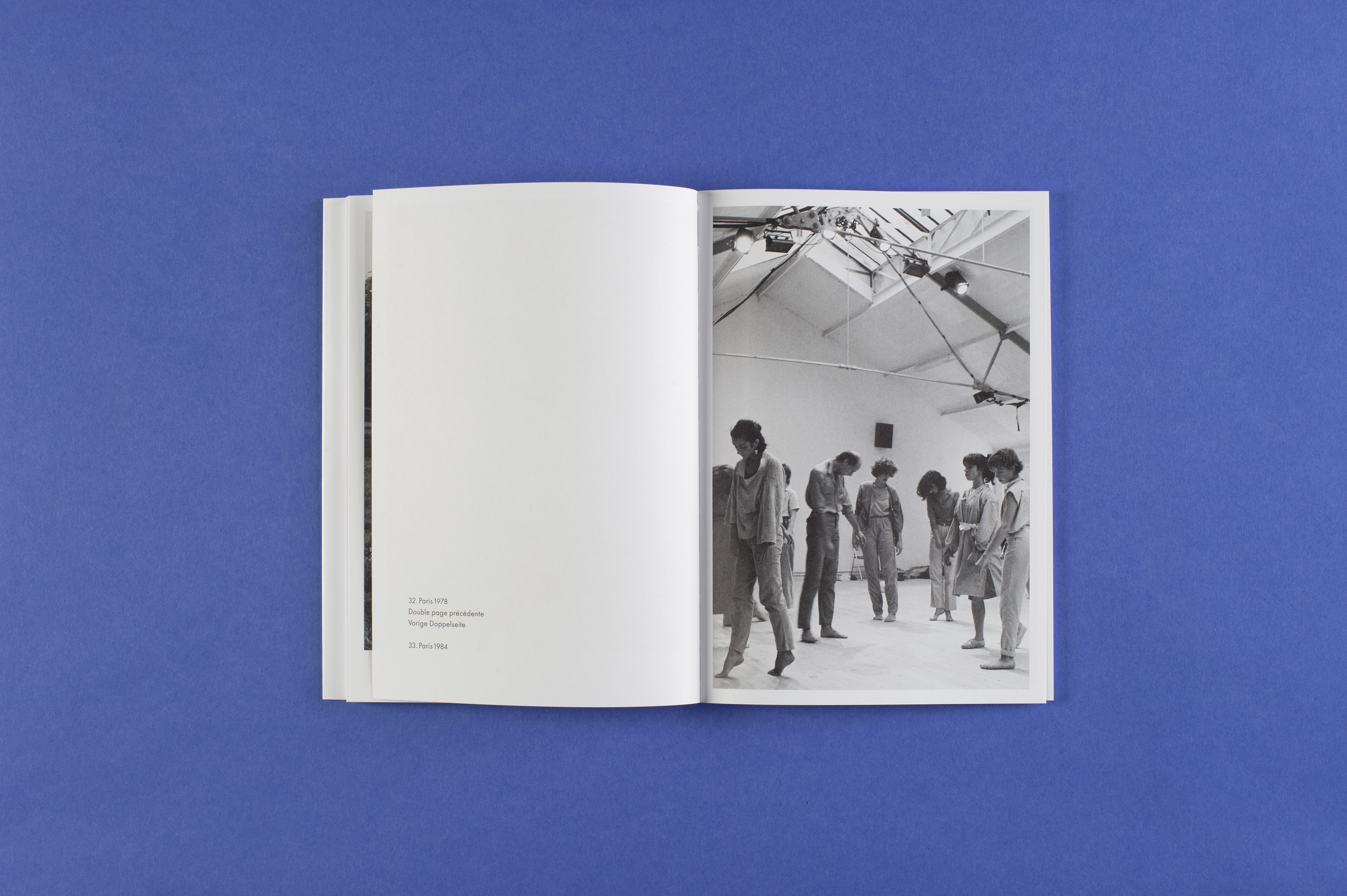 Photo of the open photo book in landscape format. The right-hand page shows a black and white photograph of a group of dancers. Possibly doing expressive dance. The title of the photo is: Paris 1978.